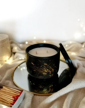Artisanal scented candle in a black container with gold motifs